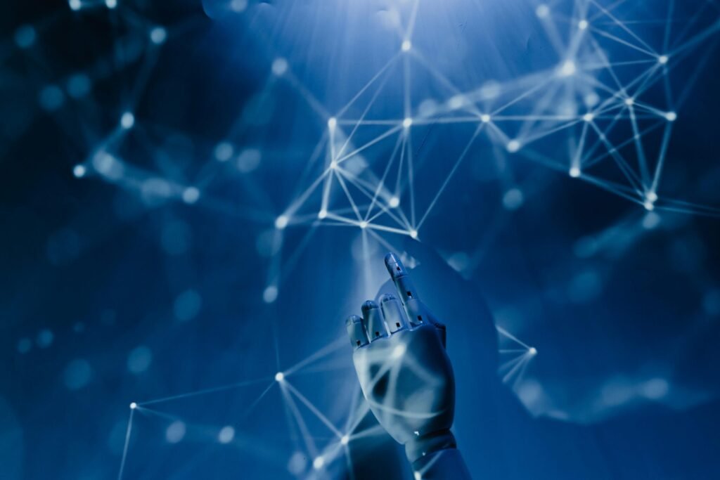 A robotic hand reaching into a digital network on a blue background, symbolizing ai technology.